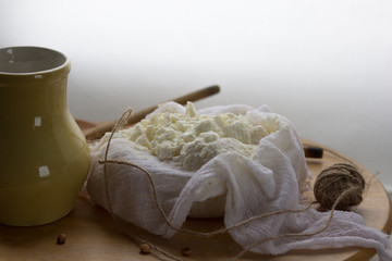 Fototapeta na wymiar fresh homemade farm creamy cottage cheese (tvorog) in cheesecloth