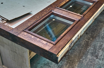 Wood door manufacturing process. Glazed door frame, painted in dark color. Furniture manufacture.
