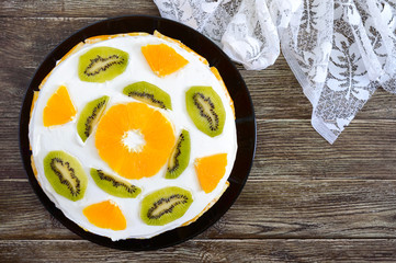 Delicious fruit cake on a wooden background, copy space. Top view. Festive cake.