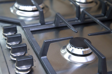 Close-up clean new kitchen gas stove cooker knob heat volume switch elegant metal steel black and...