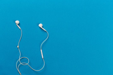 White earphones on blue background
