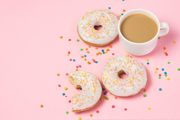 A cup of coffee with milk, Fresh tasty sweet donuts on a pink background. The concept of fast food, bakery, breakfast, sweets. Minimalism. Flat lay, top view, copy space.