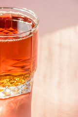 glass of apple juice on pink background. Non alcoholic beverage.