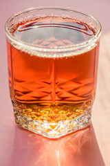 glass of apple juice on pink background. Non alcoholic beverage.