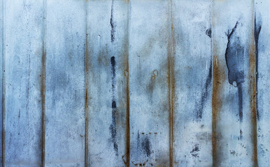Aged steel plate. Industrial texture. Distructed blue painted metal surface with red corrosion traces.