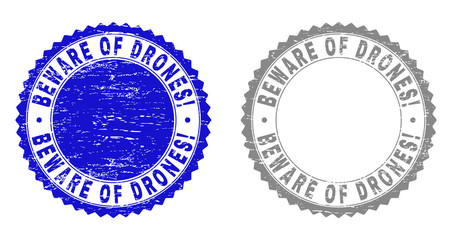 Grunge BEWARE OF DRONES! stamp seals isolated on a white background. Rosette seals with grunge texture in blue and gray colors. Vector rubber watermark of BEWARE OF DRONES! tag inside round rosette.