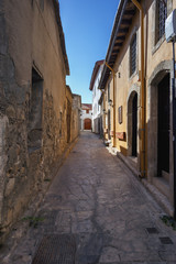 Fototapeta na wymiar narrow stone-paved street in the old part of the Greek city of Limassol