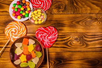 Different sweet candies on a wooden table. Top view
