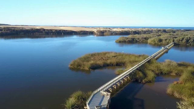 Aerial drone shot of a boardwalk on a lake in Oso Flaco, located on the Central Coast of California, Santa Barbara County