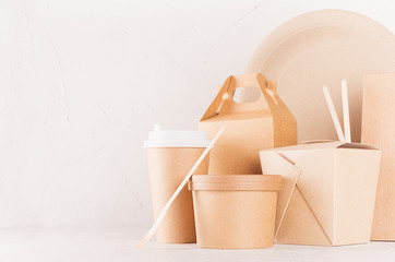 Fototapeta na wymiar Food takeaway set mockup for brand - blank kraft paper pack for asian cuisine - box for noodles, drink cup, bowl, chopsticks on white wooden table, closeup.