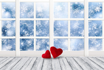 Home interior decor with window and two red hearts on wooden table in shabby chic style for Valentines Day and snowy weather outside