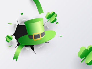 Illustration of leprechaun hat with paper origami of clover leaves on torn paper background for St Patrick's Day celebration.