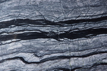 The texture of a natural stone of gray marble with black and white stripes is called Silver Wave
