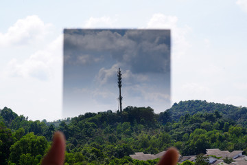 A Man hand holding gradual Neutral Density filter pointing at the sky
