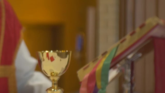 Church mass priest raises chalice as part of offertory
