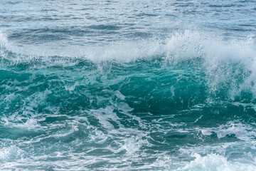 Fototapeta premium Turquoise Blue Wave Breaking and Washing into Shore in Italy