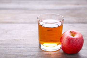 Red apples with juice on a grey background