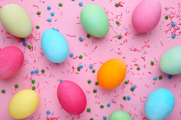 Colorful easter eggs with sprinkles on a pink background