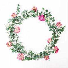 Floral frame with pink roses flowers and eucalyptus branches on white background. Flat lay, top view