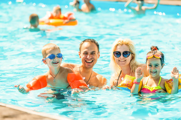 Family man woman boy girl in swimming pool, active leisure concept