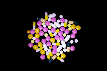Multicolored pills on black background
