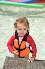 child with lifejacket in a swimming pool