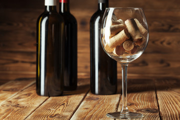 Wine bottles with glass, wooden background