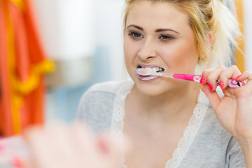 Woman brushing cleaning teeth in bathroom