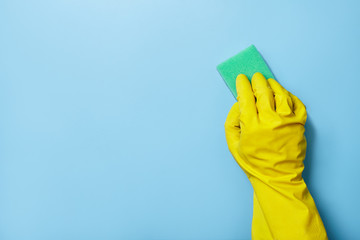 Hand cleaning on a blue background with sponge.
