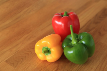 Composition with three color - red, green, yellow fresh sweet pepper or bell pepper on wooden background.
