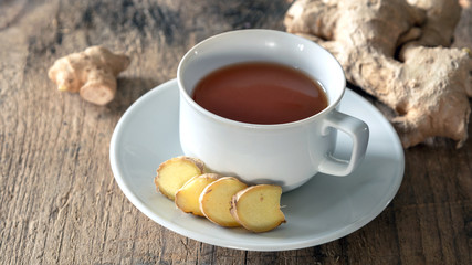 Ingwertee  mit Ingwerknolle auf Holzuntergrund