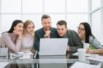 serious business team looks closely at the laptop screen