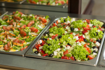 Fresh salads in boilers on the buffet table