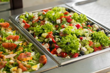Fresh salads in boilers on the buffet table