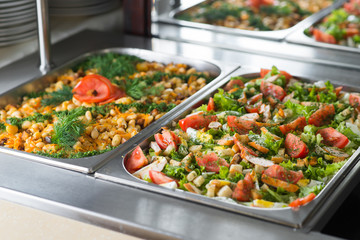 Fresh salads in boilers on the buffet table