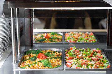 Fresh salads in boilers on the buffet table