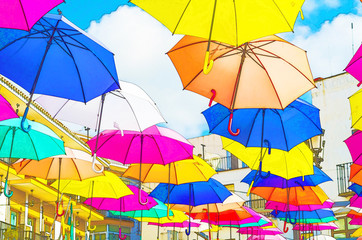 Colourful umbrellas urban street decoration. Hanging colorful umbrellas over blue sky,watercolor