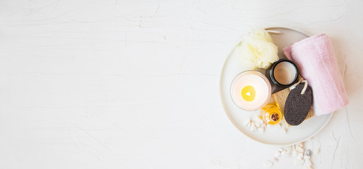 Spa still life. top view of spa products with towel, candle, oil , bath salt in white tray with copy space