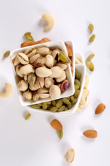 ssorted nuts on white, dry fruits, mix nuts, almond, cashew, pistachio, raisin