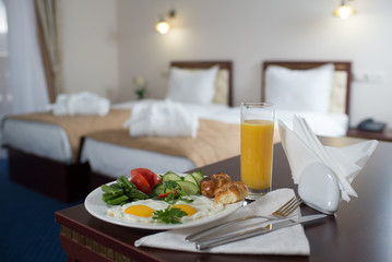 fresh breakfast with scrambled eggs and orange juice in the hotel room