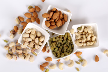 ssorted nuts on white, dry fruits, mix nuts, almond, cashew, pistachio, raisin