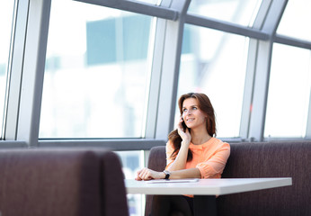 woman consultant with smartphone sitting at her Desk in the office