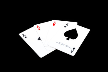 A winning poker hand of four aces playing cards suits on black.