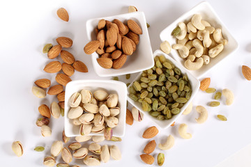 ssorted nuts on white, dry fruits, mix nuts, almond, cashew, pistachio, raisin