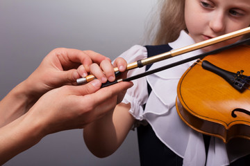 Beautiful little girl playing the violin on gray background © laboko