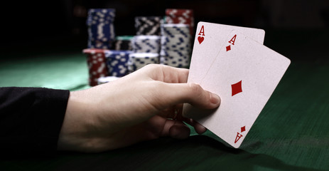 Obraz premium closeup. casino chips and playing cards in the player's hand.