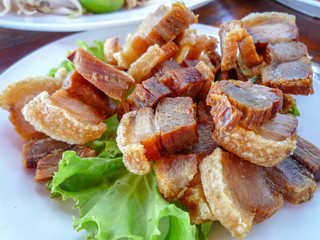 close up of Crispy fried Pork served with green salad at the restaurant in Thailand  