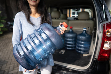 woman put a gallon of water in the car trunk at home. wanted to purchase the refill or by the new...
