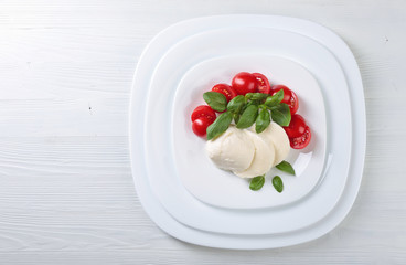 Mozzarella with tomato and green basil.