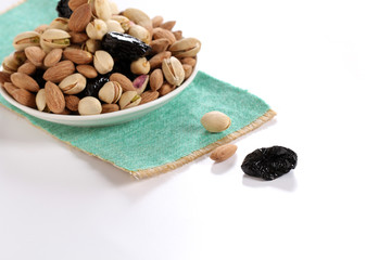 Assorted nuts on white, dry fruits, mix nuts, roasted almond, prunes, pistachio